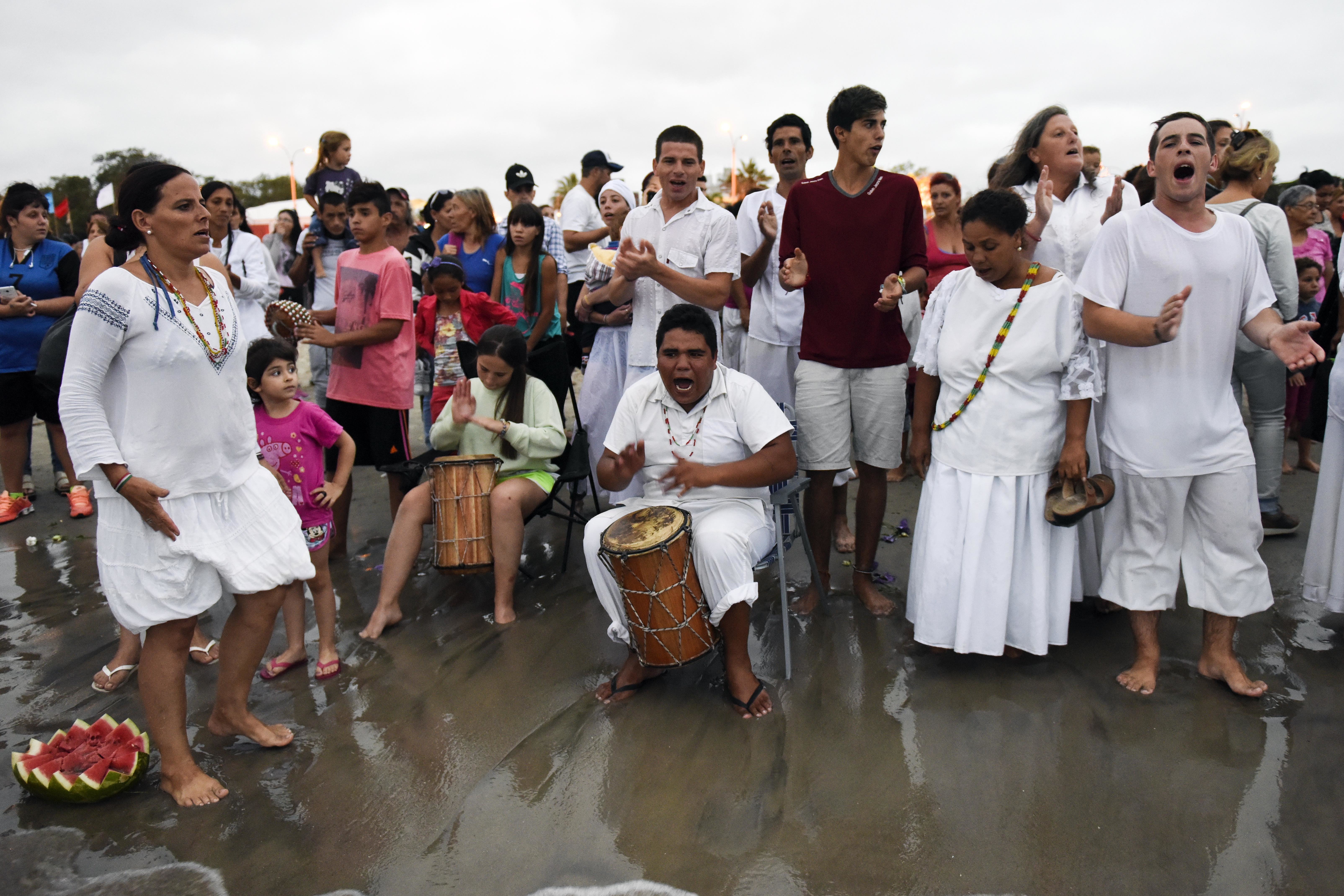 Worshippers sing to honor the African sea goddess Yemanja, at the sea shore in Montevideo, Uruguay, Thursday, Feb. 2, 2017. Thousands of worshippers come to the beach on Yemanja's feast day, bearing candles, flowers, perfumes and fruit to show their gratitude for her blessings. The celebration coincides with the Roman Catholic feast day of the Virgin of Candelaria, marked Feb. 2. (AP Photo/Matilde Campodonico)