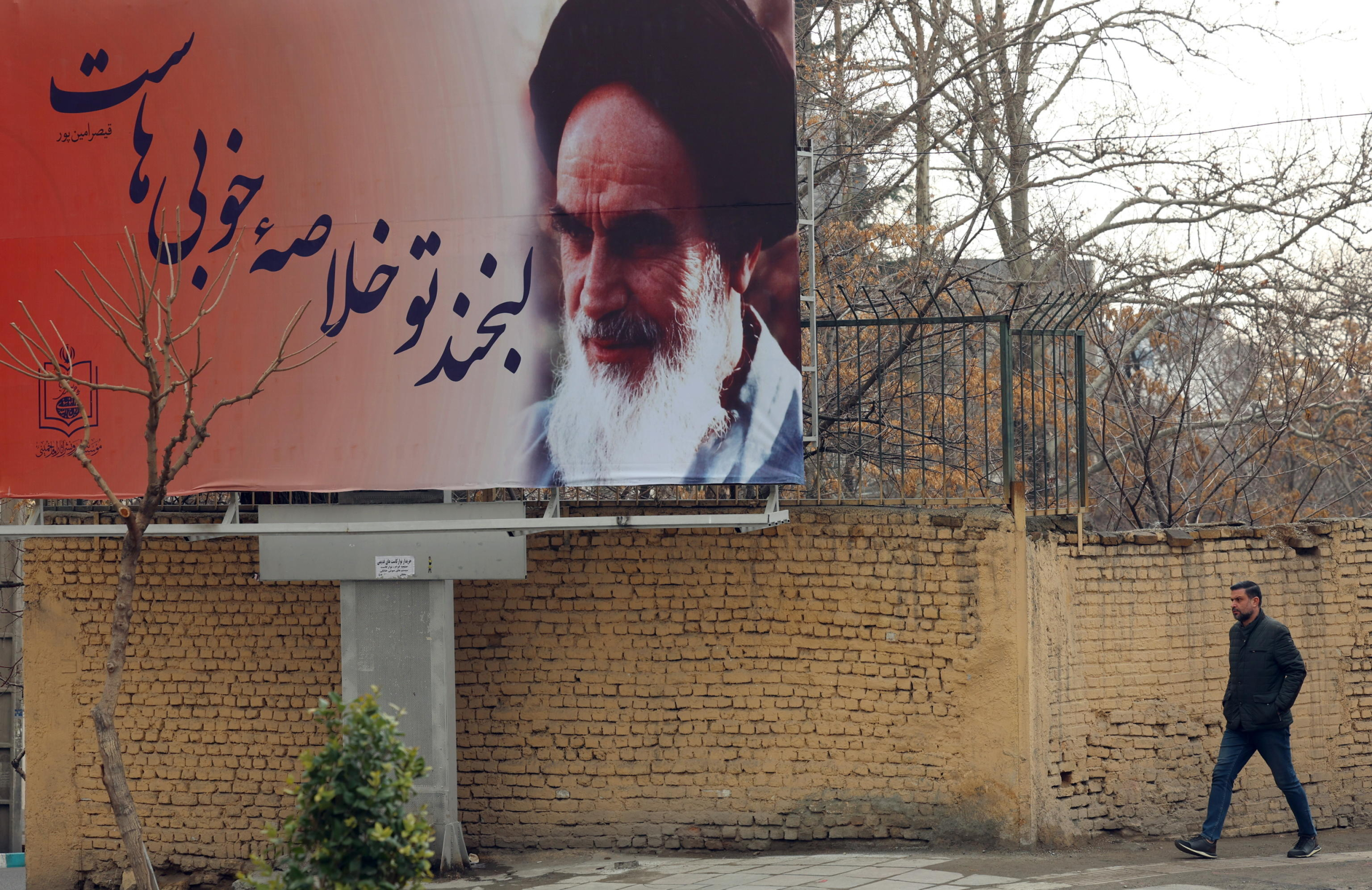 epa11865379 An Iranian man walks past a picture of Iranian late supreme leader Ayatollah Ruhollah Khomeini as the country marks the 46th anniversary of Khomeini's return from his Paris exile, in Tehran, Iran, 31 January 2025. Iran will celebrate its 45th revolution anniversary on 10 February 2025.  EPA/ABEDIN TAHERKENAREH