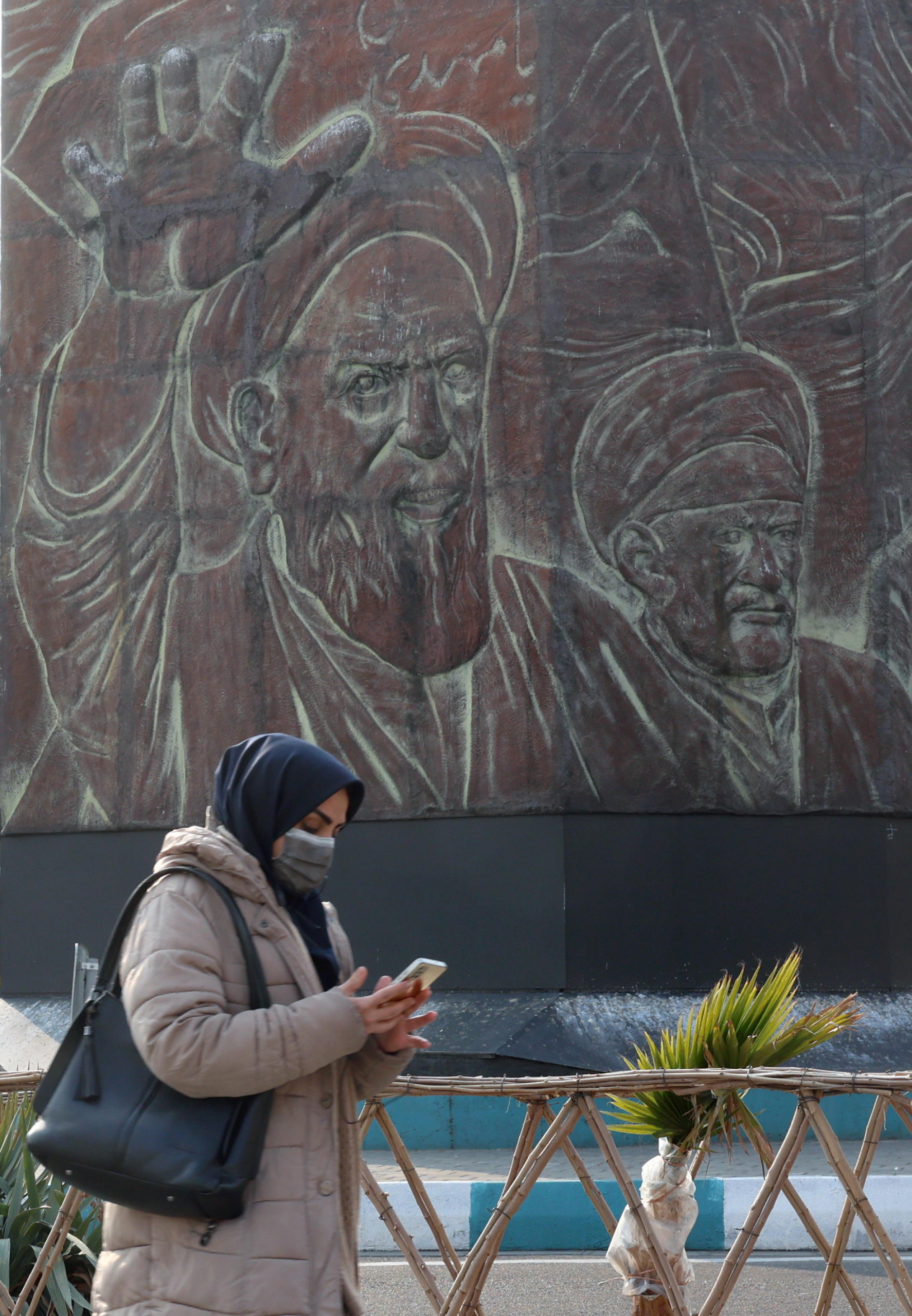 epa11865387 An Iranian woman walks past next to statue of Iranian late supreme leader Ayatollah Ruhollah Khomeini as the country marks the 46th anniversary of Khomeini's return from his Paris exile, in Tehran, Iran, 31 January 2025. Iran will celebrate its 45th revolution anniversary on 10 February 2025.  EPA/ABEDIN TAHERKENAREH