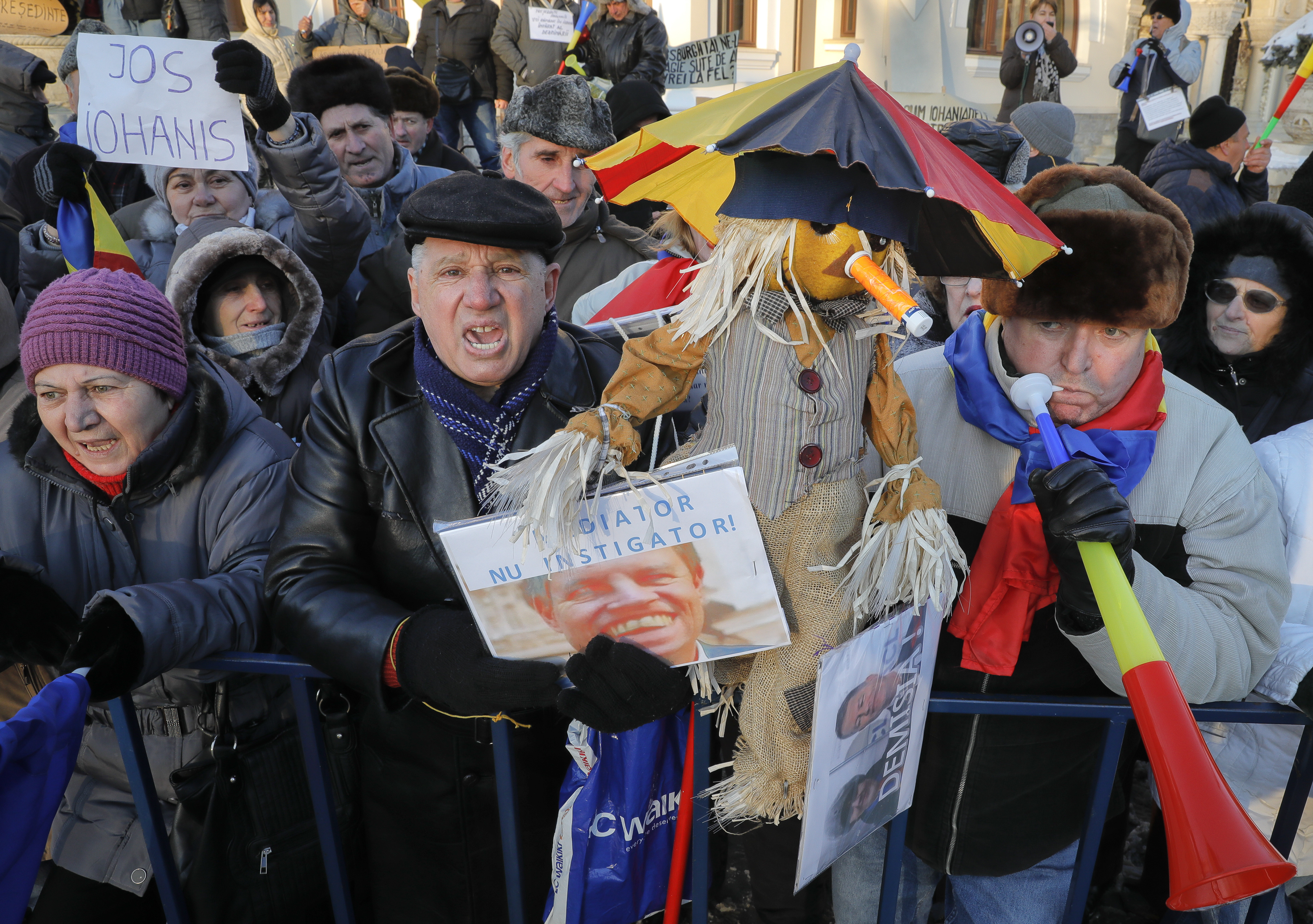 Pro-government demonstrators shout slogans against Romanian President Klaus Iohannis holding a banner that reads 