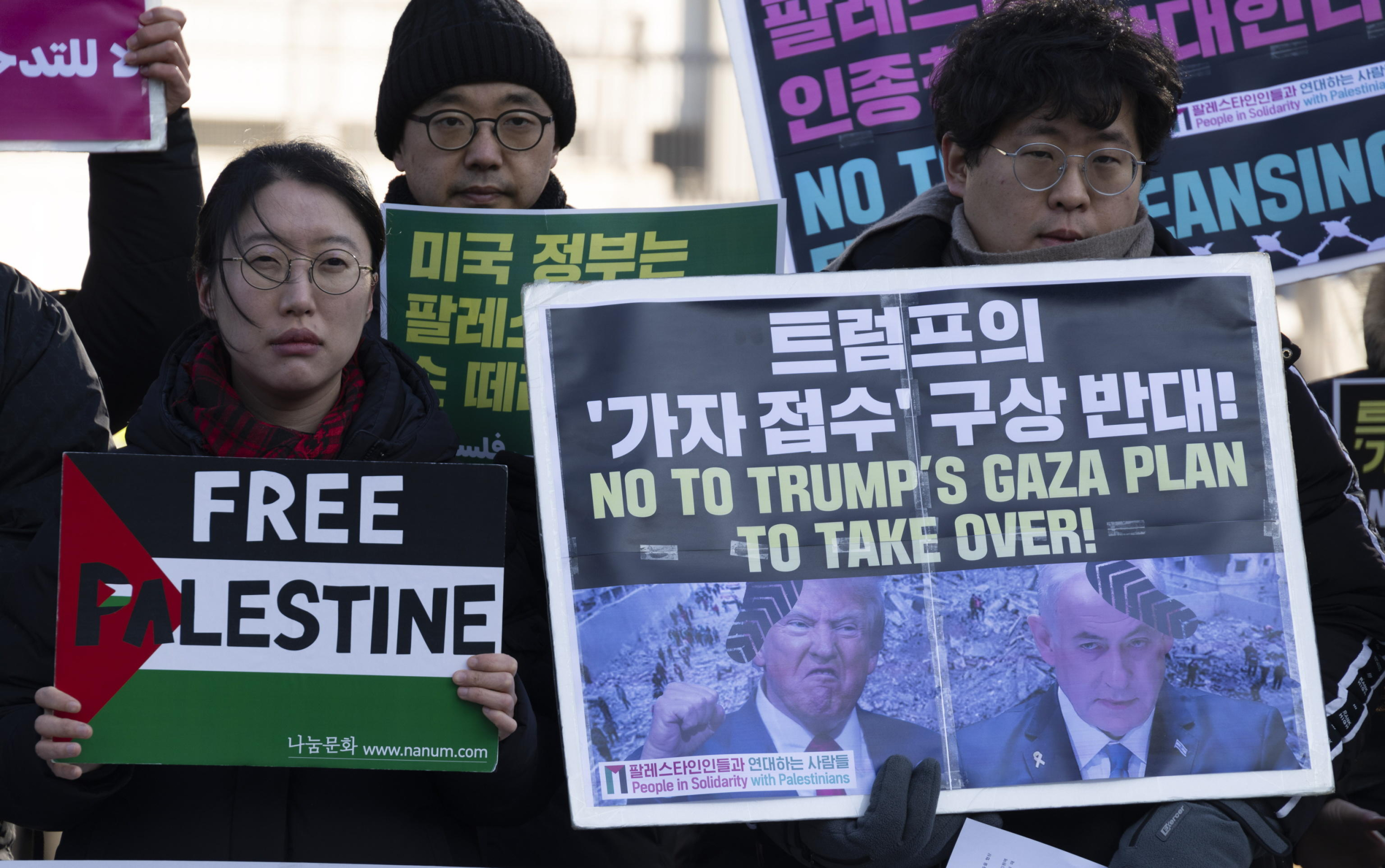 epaselect epa11875944 Members of the People in Solidarity with Palestinians group hold placards featuring images of Israeli Prime Minister Benjamin Netanyahu and US President Donald J. Trump with the words 