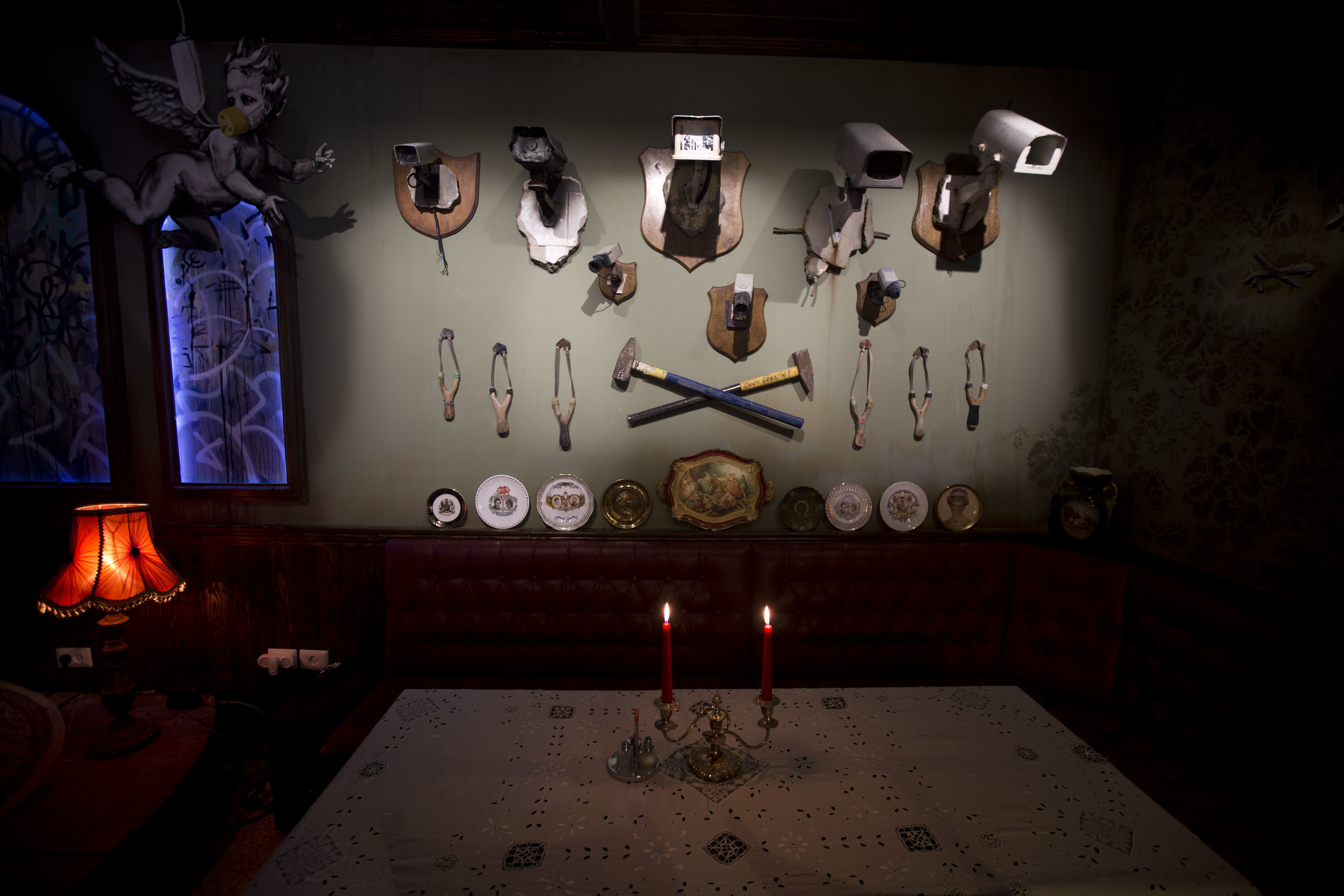 A wall decorated with security cameras and slingshots is seen in the bar area of the 