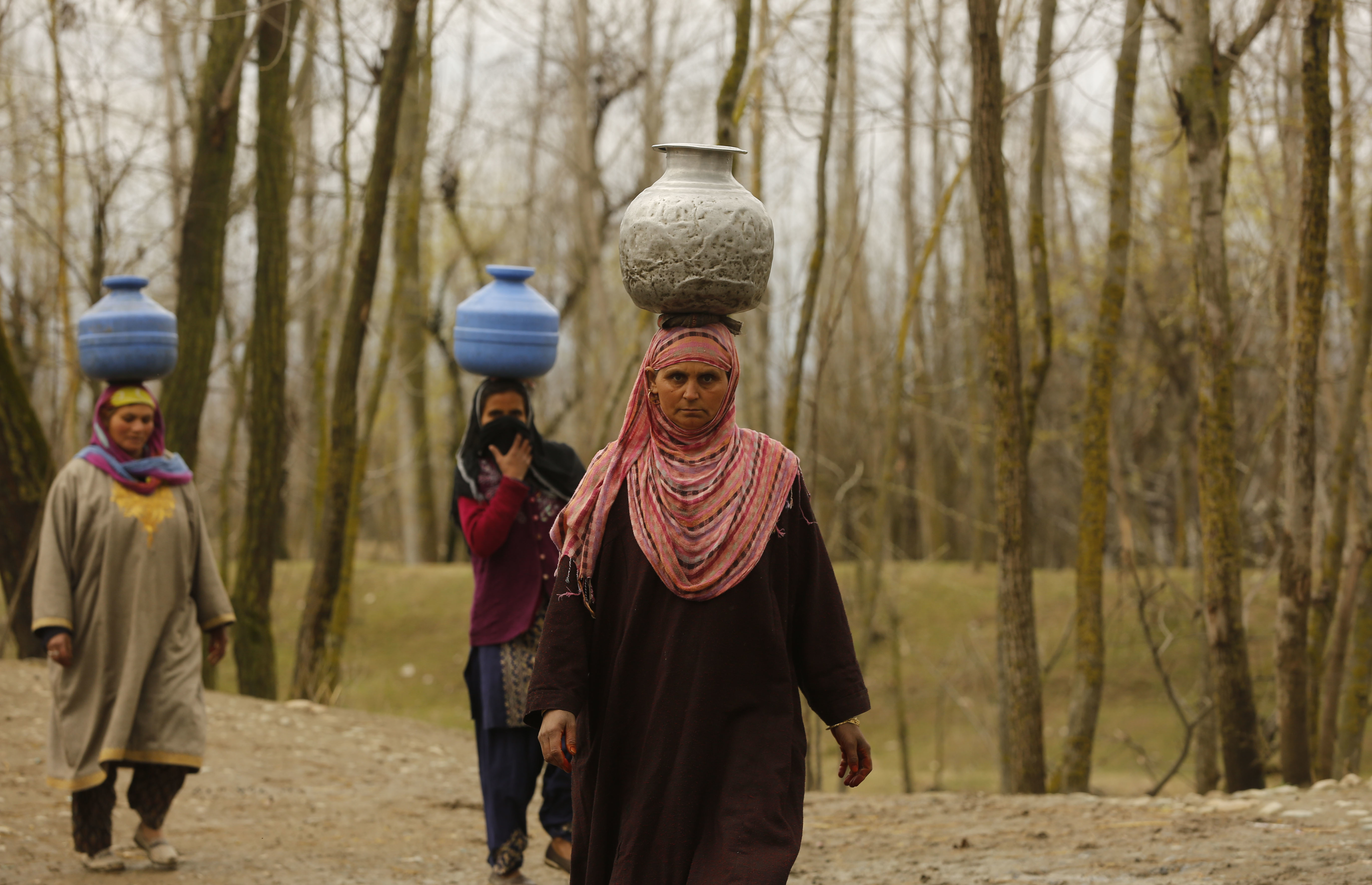 Kashmiri village women walk towards their home after collecting water from a river, on World Water Day in Dasilpora, north of Srinagar, Indian controlled Kashmir, Wednesday, March 22, 2017.  India has the world's highest number of people without access to clean water. According to UNICEF, the U.N.'s children's agency, nearly 78 million Indians — or about 5 percent of the country's 1.3 billion population — must make do with contaminated water sources or buy water at high rates. (AP Photo/Mukhtar Khan)