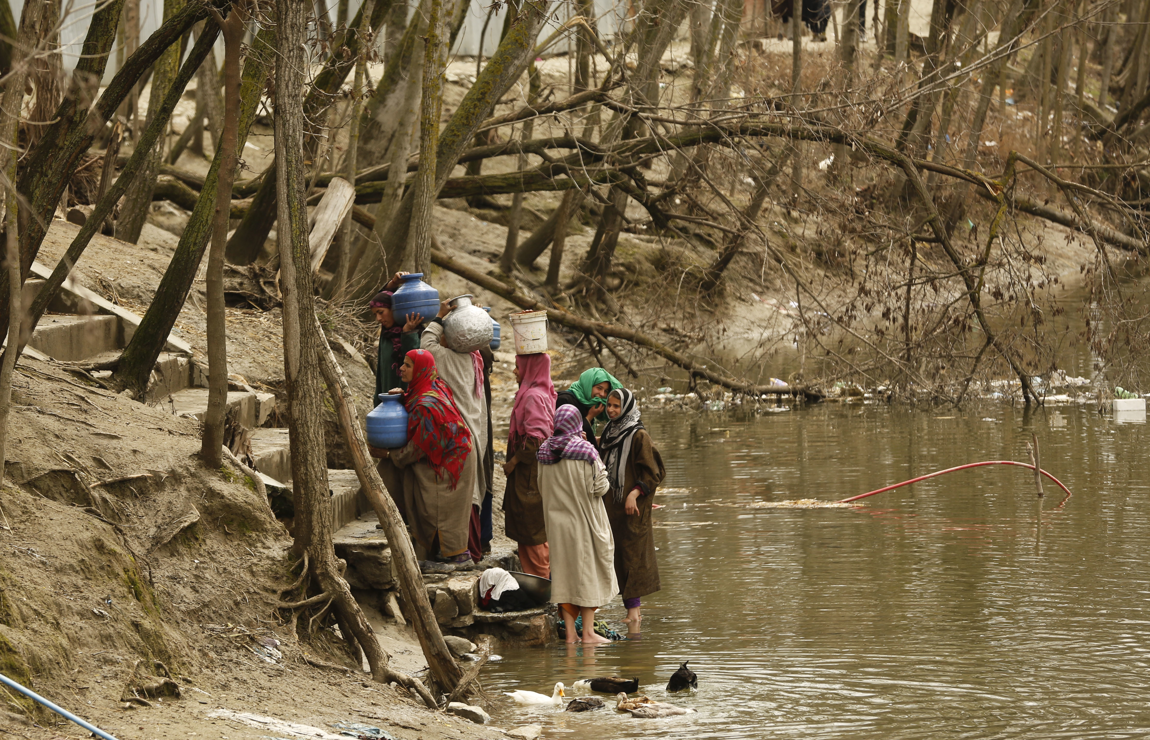 Kashmiri village women prepare to walk towards their home after collecting water from a river, on World Water Day in Dasilpora, north of Srinagar, Indian controlled Kashmir, Wednesday, March 22, 2017.  India has the world's highest number of people without access to clean water. According to UNICEF, the U.N.'s children's agency, nearly 78 million Indians — or about 5 percent of the country's 1.3 billion population — must make do with contaminated water sources or buy water at high rates. (AP Photo/Mukhtar Khan)