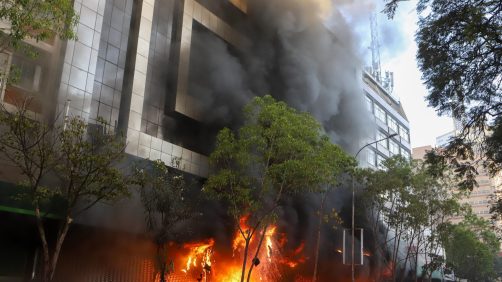 Fiamme e fumo fuoriescono da un centro commerciale in fiamme durante una protesta vicino al Parlamento contro gli aumenti delle tasse, a Nairobi, in Kenya, il 25 giugno 2024. Foto Ansa EPA/STR