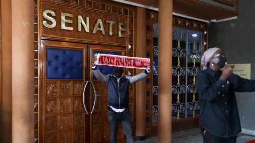 Un manifestante espone uno striscione dopo aver fatto irruzione in Parlamento durante una protesta contro l'aumento delle tasse a Nairobi, in Kenya, il 25 giugno 2024. Foto Ansa EPA/DANIEL IRUNGU