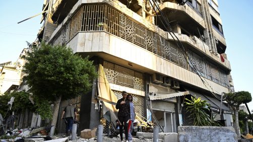 epa11639141 People stand near a damaged building following an Israeli airstrike in Beirut's Bachoura neighborhood, Lebanon, 03 October 2024. Lebanese officials reported that an Israeli airstrike on a building in central Beirut resulted in at least five deaths and eight injuries.  EPA/WAEL HAMZEH