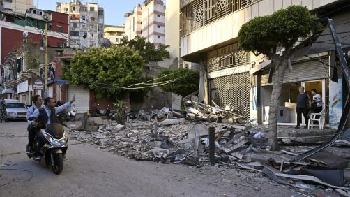 epa11639145 People ride a motobike near debris following an Israeli airstrike in Beirut's Bachoura neighborhood, Lebanon, 03 October 2024. Lebanese officials reported that an Israeli airstrike on a building in central Beirut resulted in at least five deaths and eight injuries.  EPA/WAEL HAMZEH